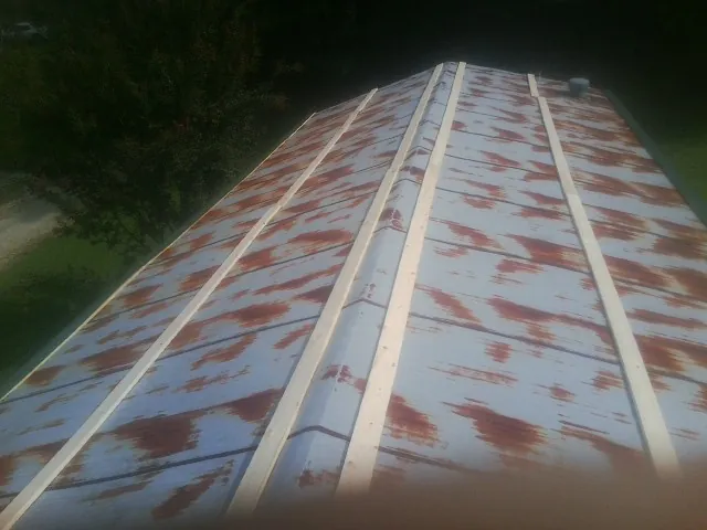 Rusted metal roof panels with new wood purlins before replacement — Storm Damage Roof Repair in Indianola by Roofing Brothers