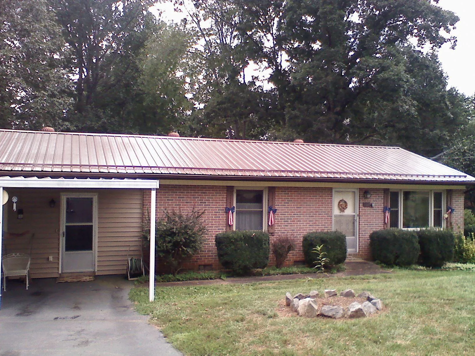Bronze metal roof and carport on a brick ranch home — Roof Repair work by our crew in Indianola
